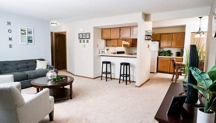 a living room and kitchen with a couch and a table