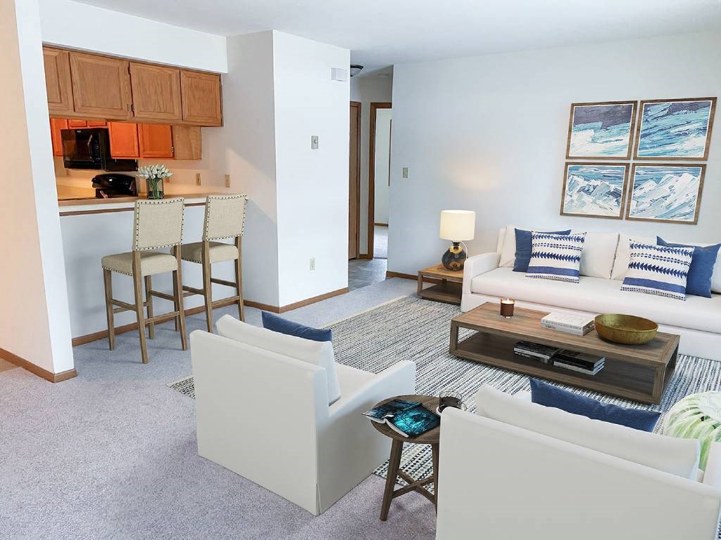 a living room and kitchen with a couch and chairs