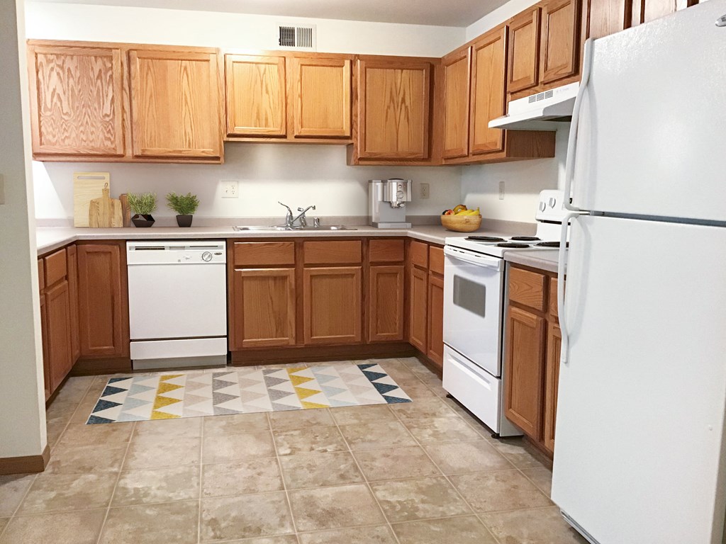 a kitchen with white appliances and wooden cabinets