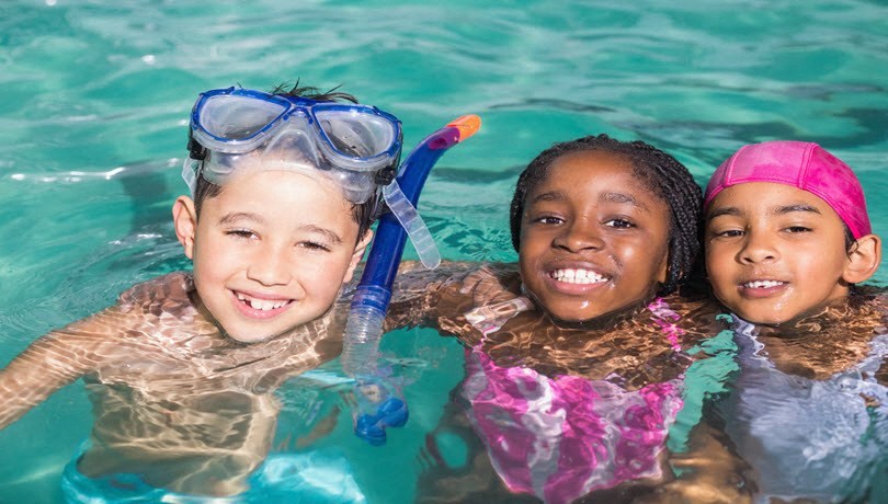 a group of children swimming in a pool