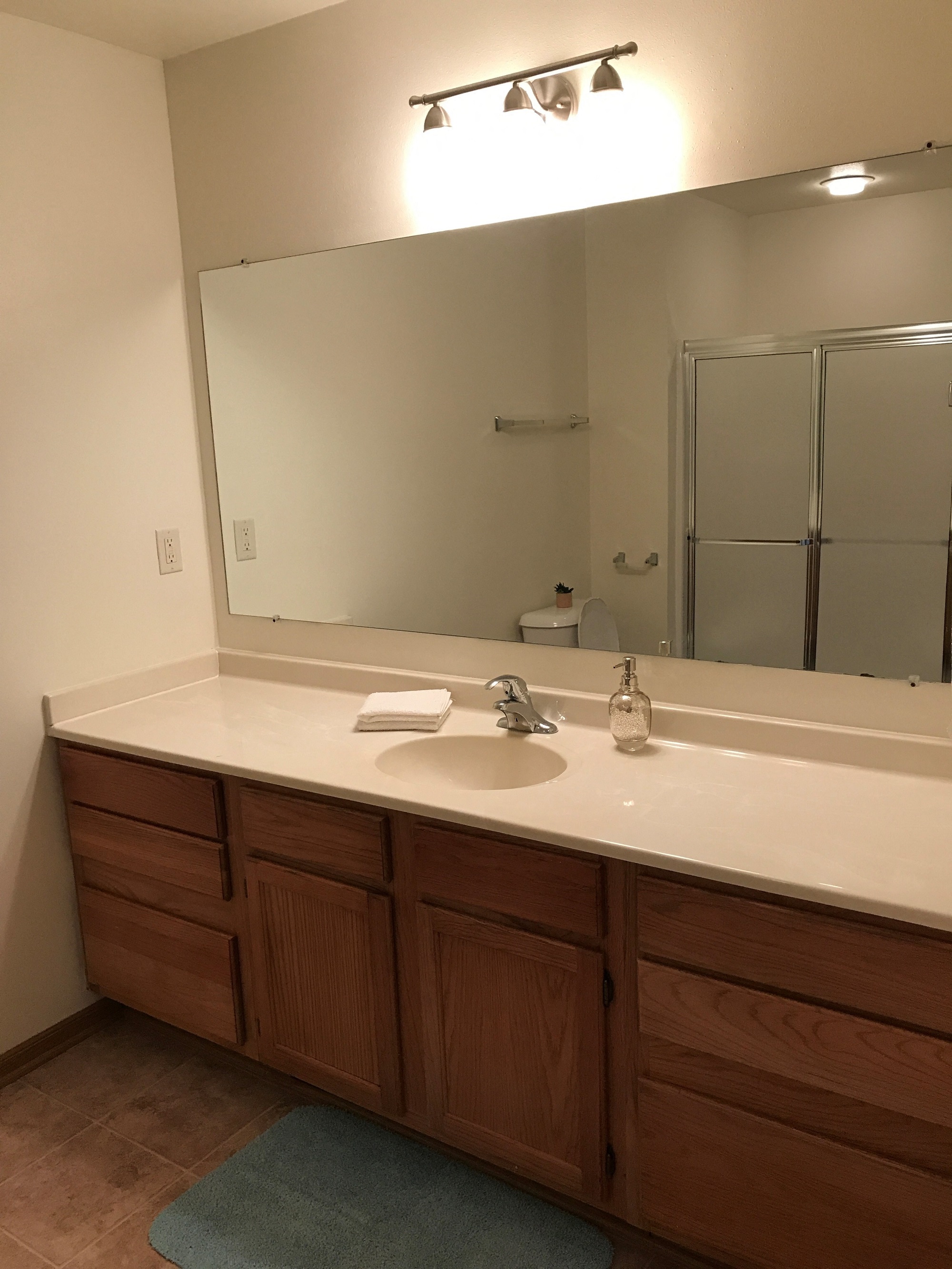 bathrooms with large vanities and mirrors and walk in shower