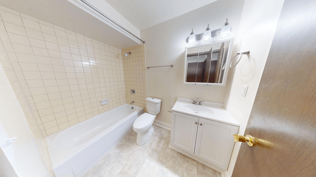 a white bathroom with a tub and a sink and a toilet