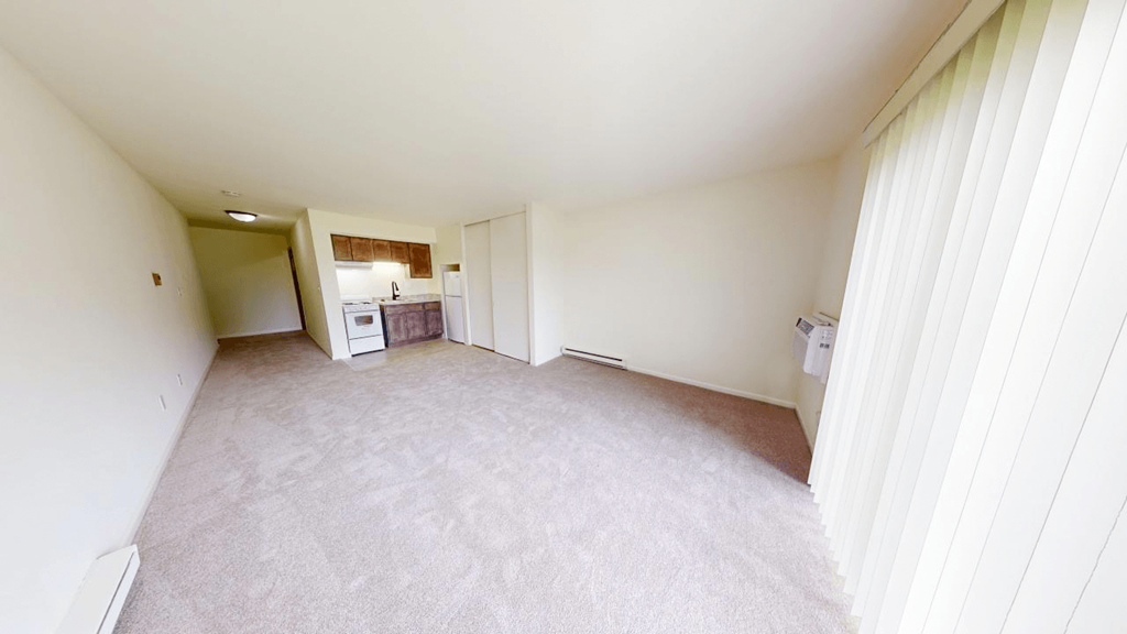 an empty living room with a kitchen in it