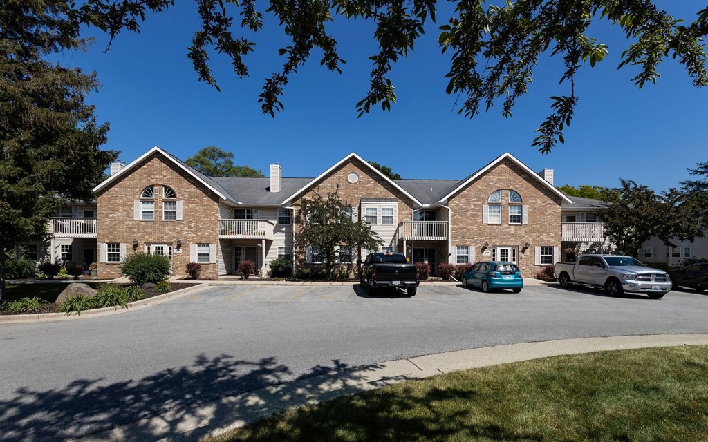 a large brick house with cars parked in front of it
