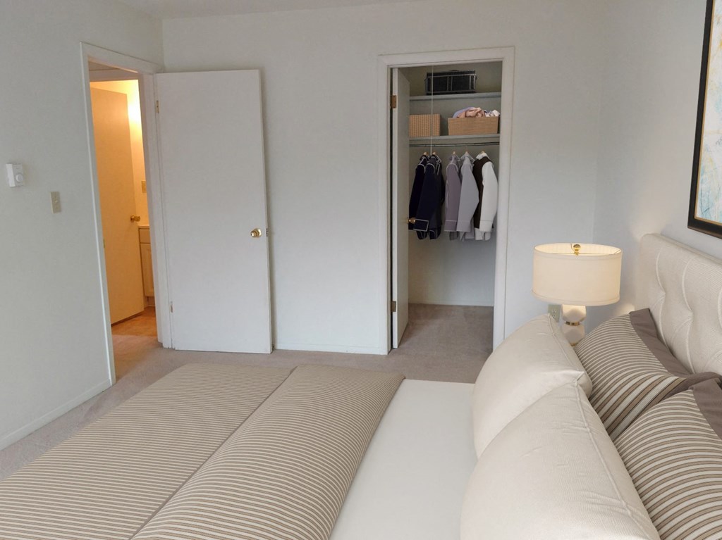 a bedroom with a bed and a closet and a lamp