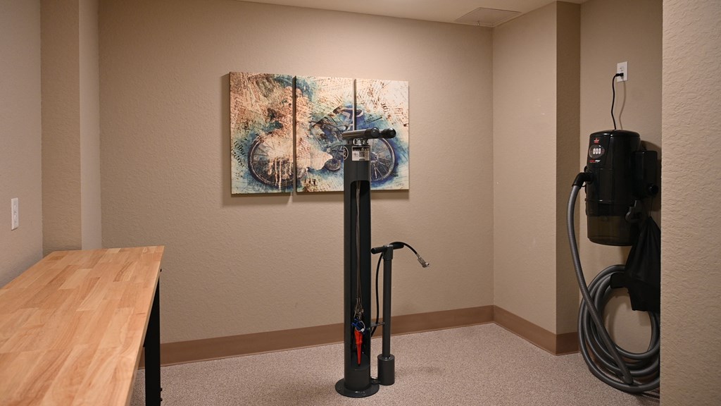 a room with a vacuum cleaner and a painting on the wall