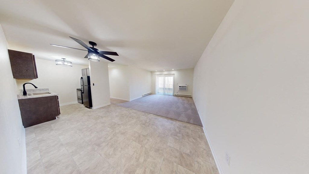 an empty living room with a ceiling fan