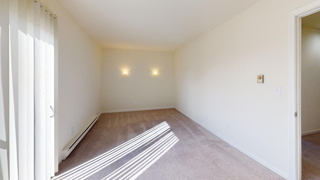 a living room with carpet and white walls