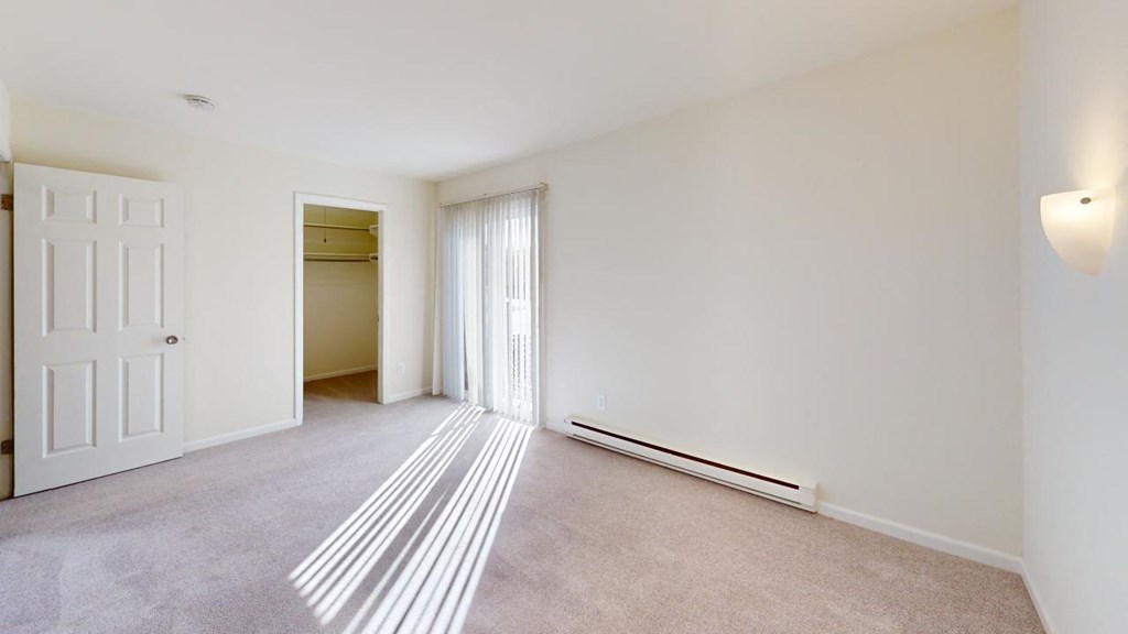 a living room and bedroom with a door to a closet