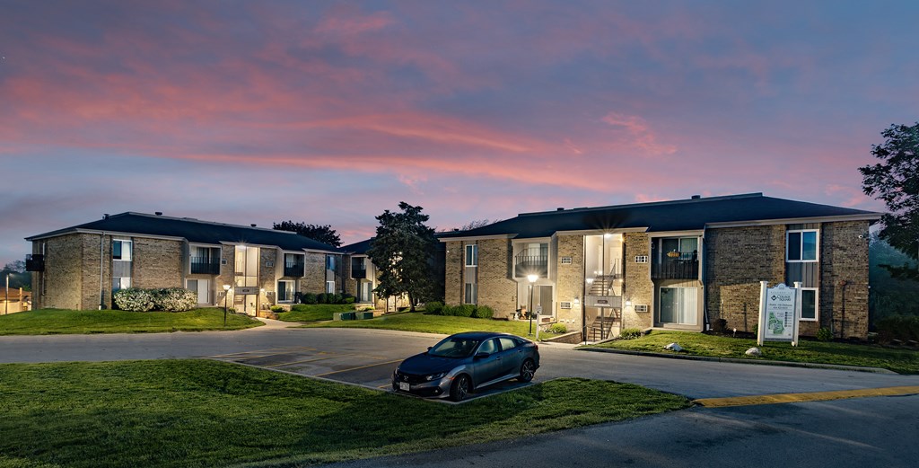 a car parked in front of an apartment building at sunset