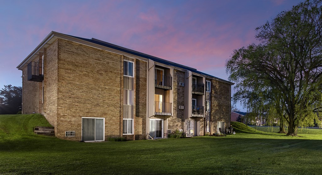 an exterior view of a brick apartment building at dusk