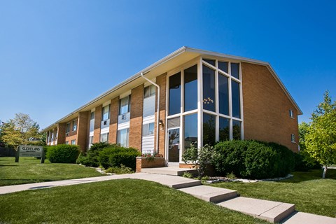 the front of a brick building with large glass windows