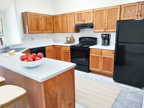 a kitchen with black appliances and wooden cabinets