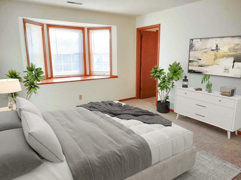 a bedroom with a bed and a large window