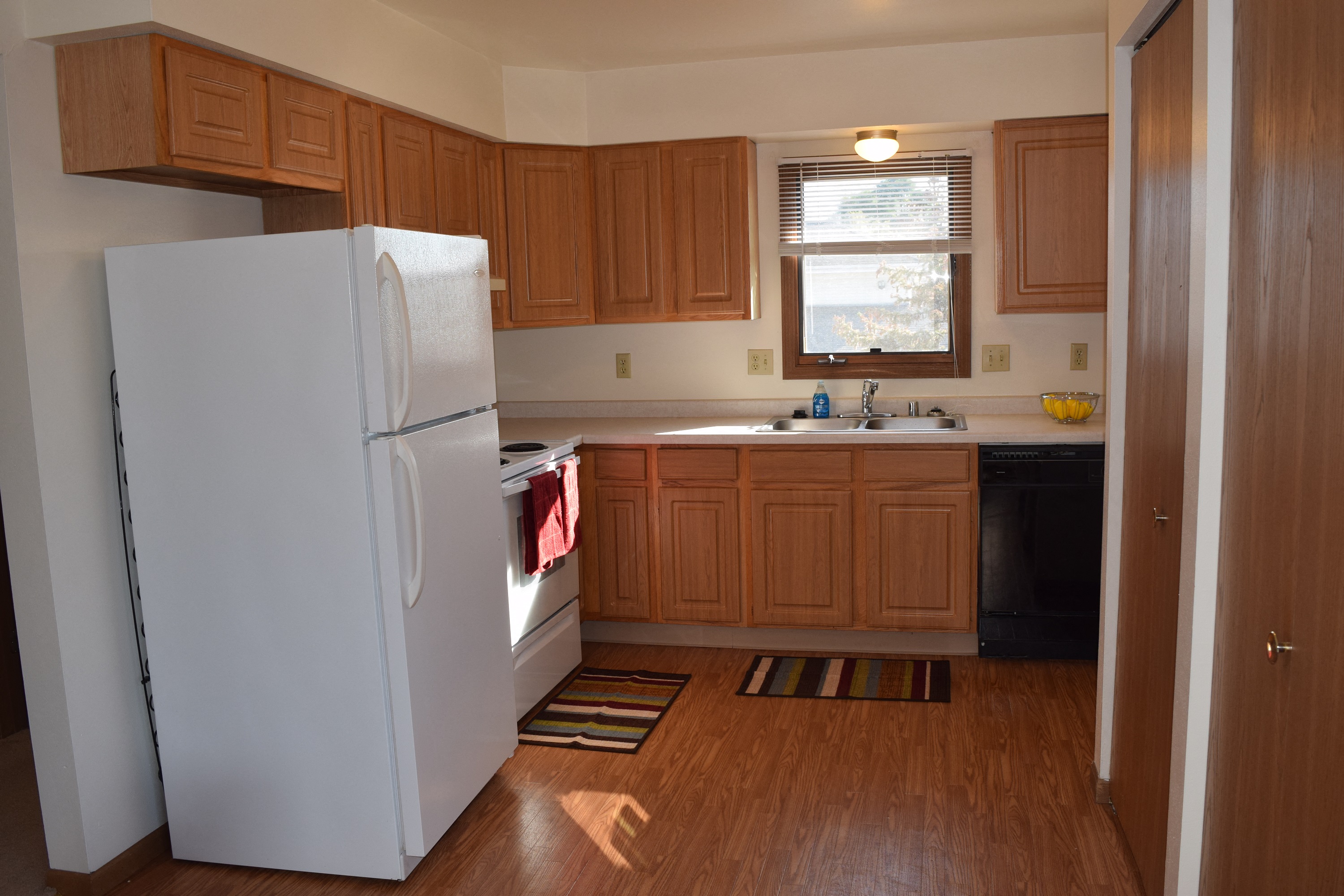 a kitchen with wooden cabinets and a white refrigerator