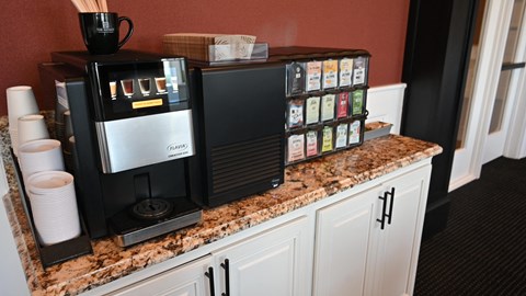 a coffee machine on a kitchen counter with a counter top full of coffee and coffee