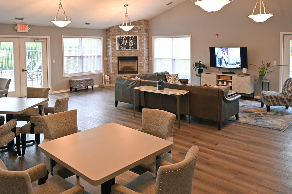 A large room with a fireplace and a TV on the wall.