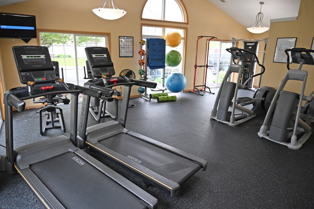 A gym with treadmills, exercise bikes, and other equipment.