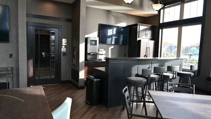 a restaurant with a bar and chairs and a television