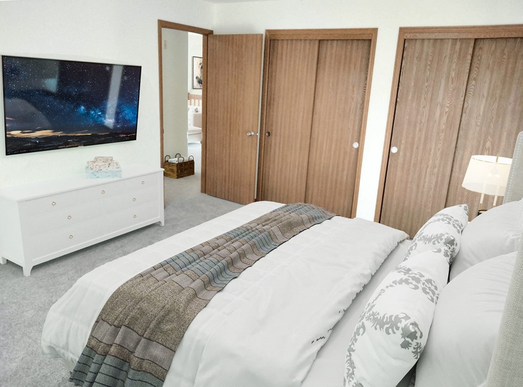 a bedroom with a bed and a tv on the wall