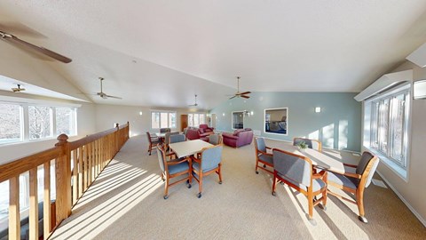 A sunny day in a spacious room with a long table and chairs.