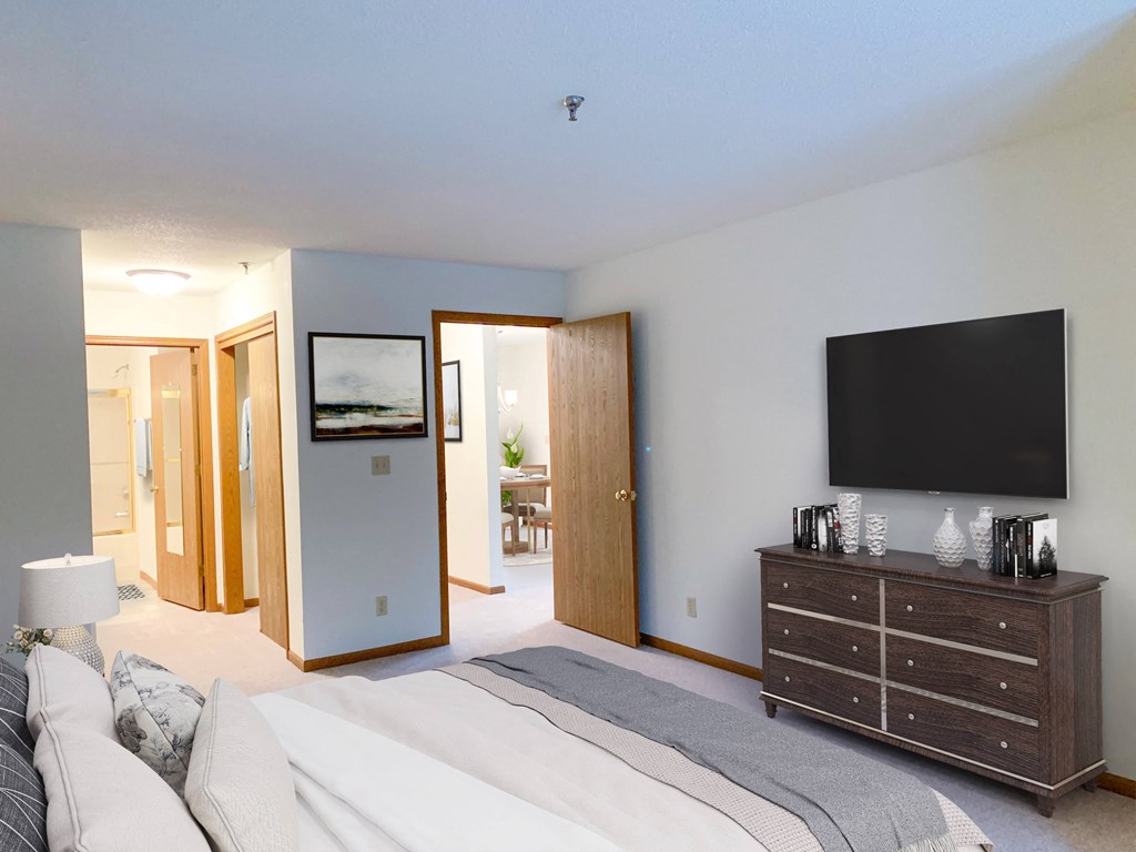 a bedroom with a bed and a dresser and a tv