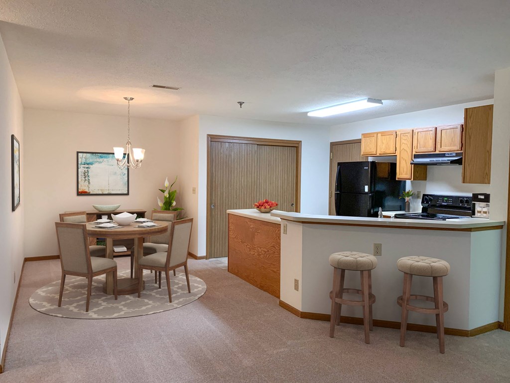 a kitchen and dining room with a bar and a table