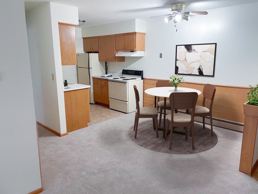 a dining room with a table and a kitchen