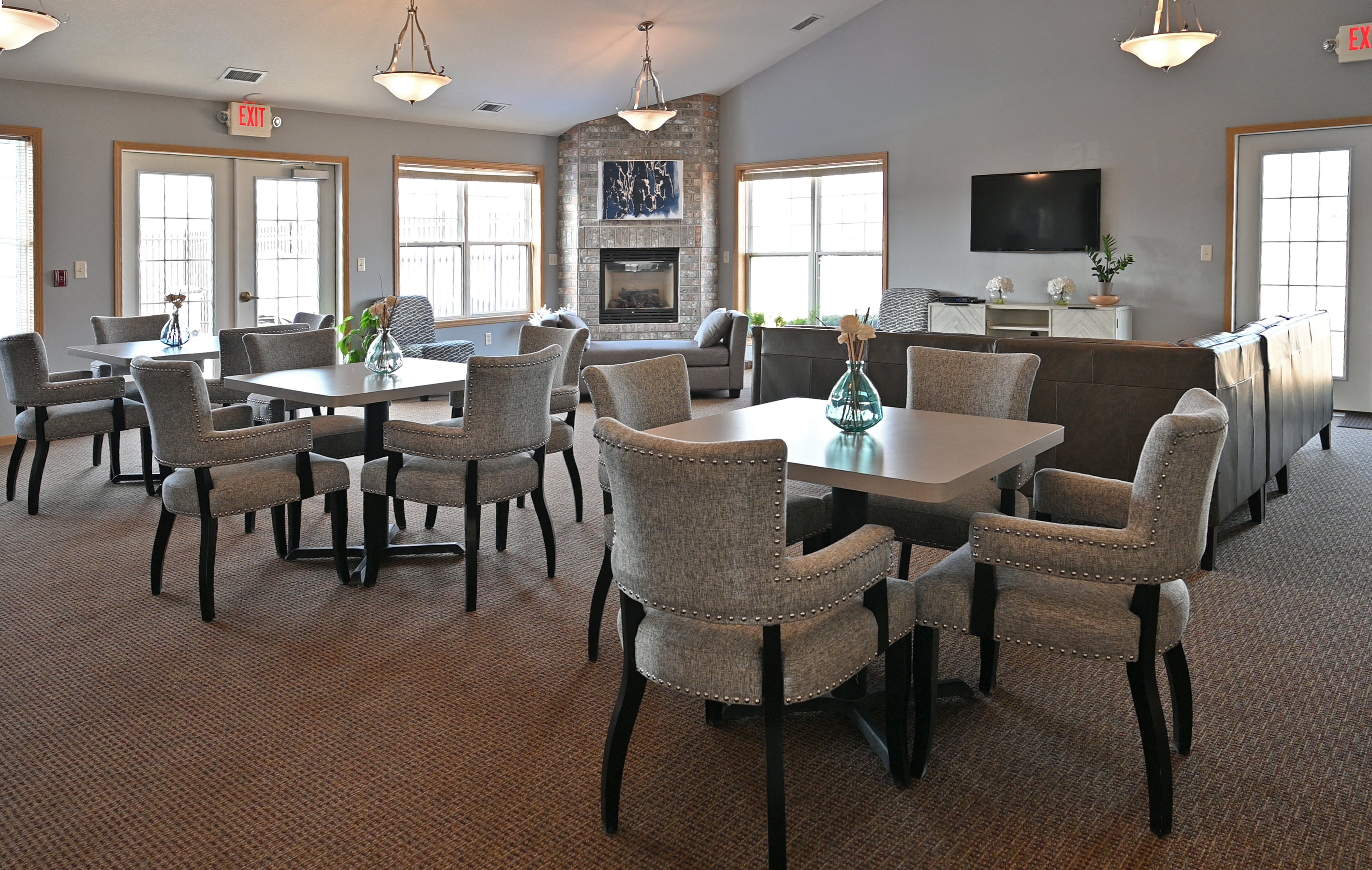 a large dining room with tables and chairs and a fireplace