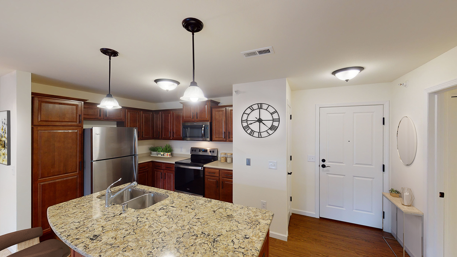 a kitchen with a granite counter top and a stainless steel refrigerator