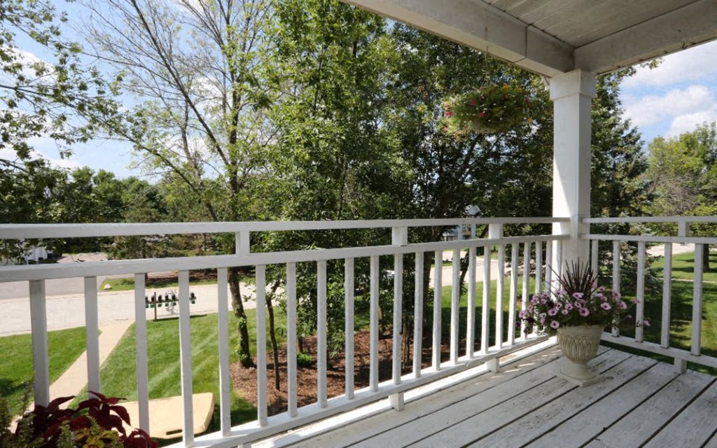 A white porch with a flower pot on it.