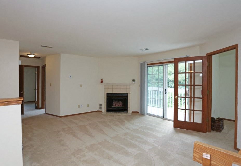 A living room with a fireplace and sliding glass doors.