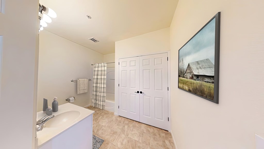 A bathroom with a white sink and a white door.