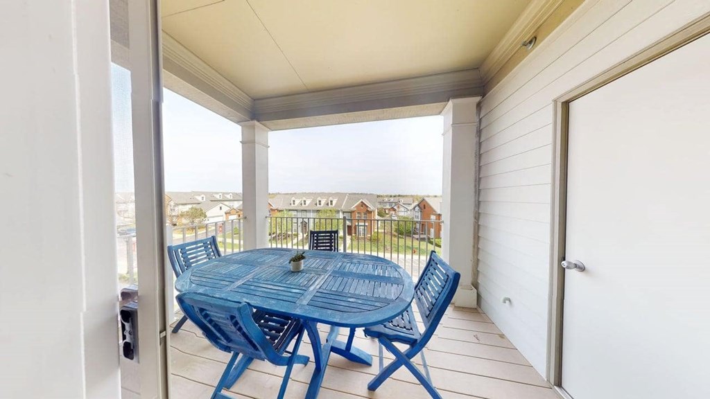 A blue table and chairs are on a porch.