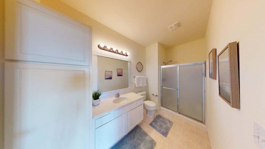 A bathroom with a white sink and a white toilet.