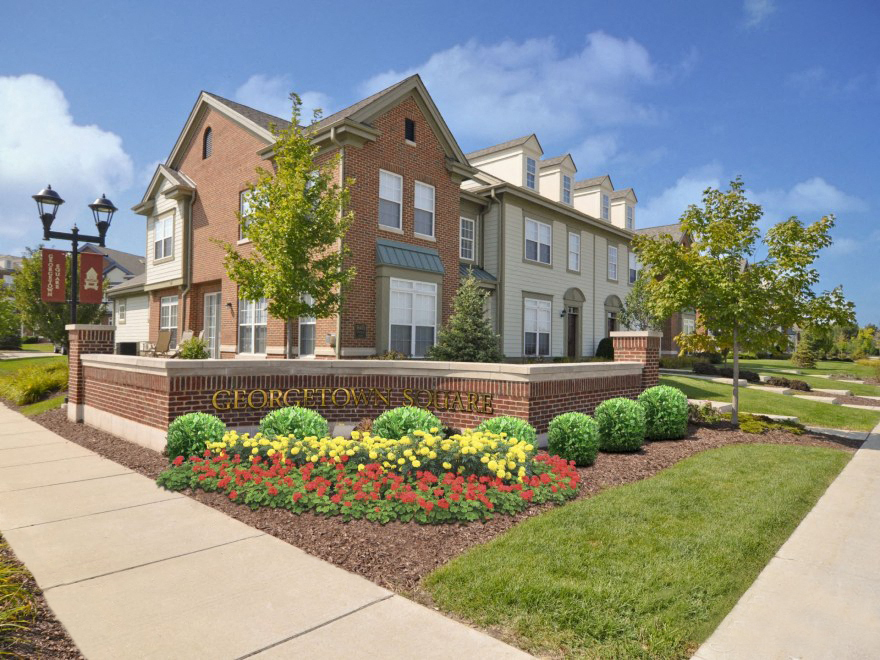 front view of the apartments building with sidewalk and landscaping