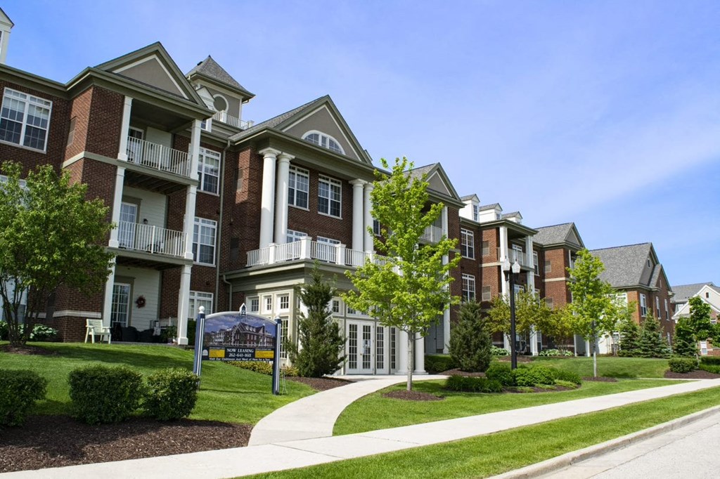 a row of town houses on a sidewalk with a sign in front