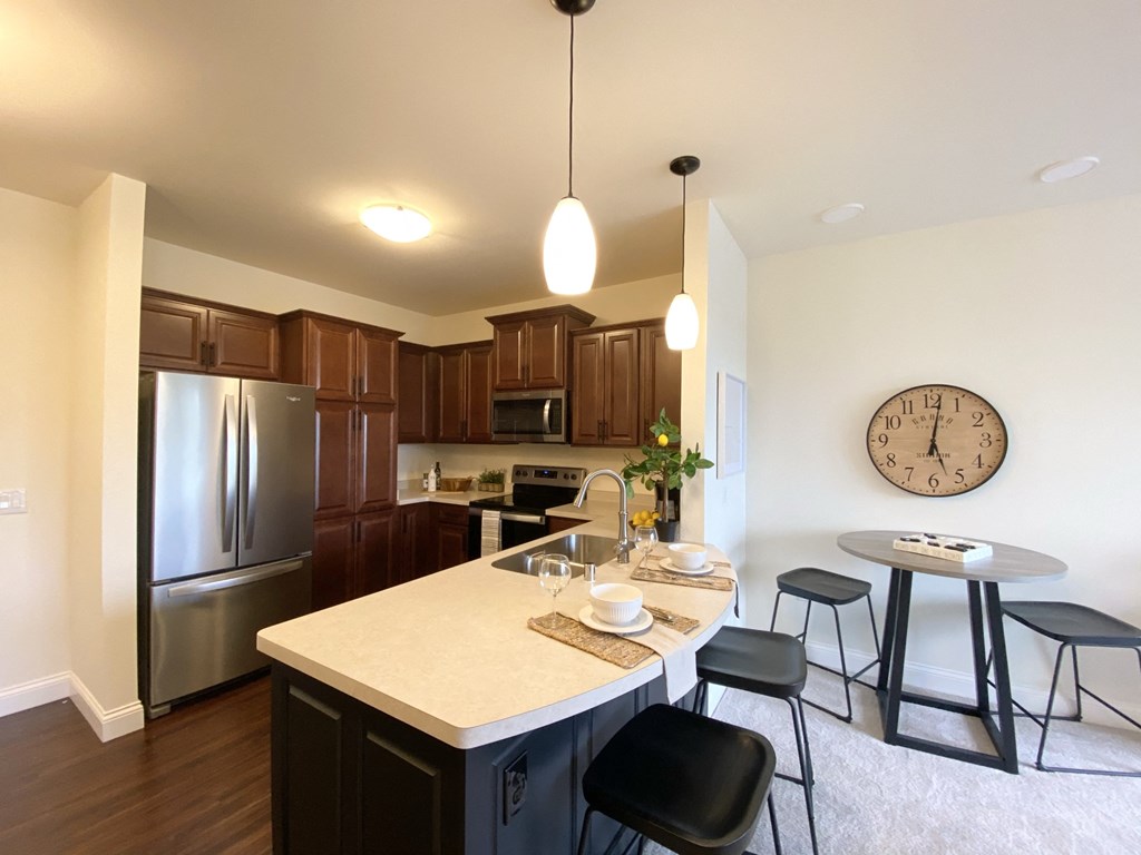 a kitchen with stainless steel appliances and a large clock on the wall