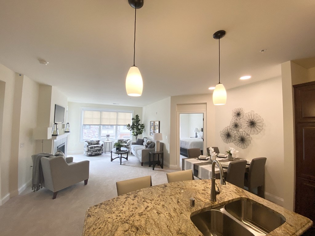 the view from the kitchen into the living room and dining area of a home