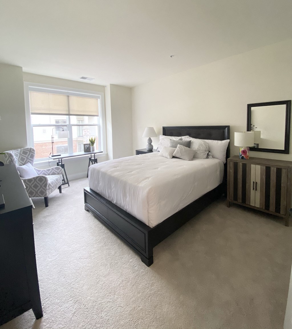 the master bedroom has a large bed and a large window