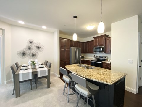 an open kitchen and dining room with a marble counter top