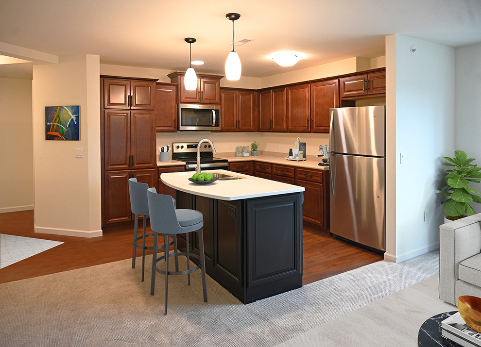 a kitchen with a center island and a stainless steel refrigerator