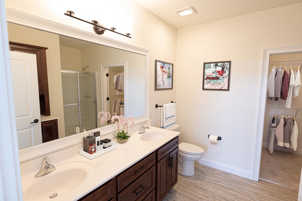 a bathroom with a large mirror and a sink and a toilet