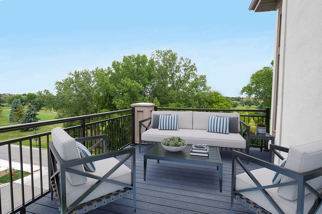 a patio with a couch and chairs on a balcony