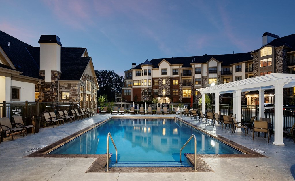 a swimming pool in front of an apartment building at night