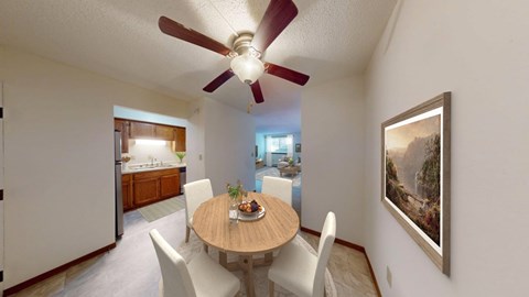 A dining room with a table set for two and a painting on the wall.