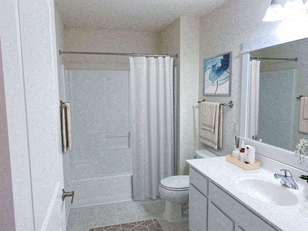 a white bathroom with a shower and a sink and a toilet