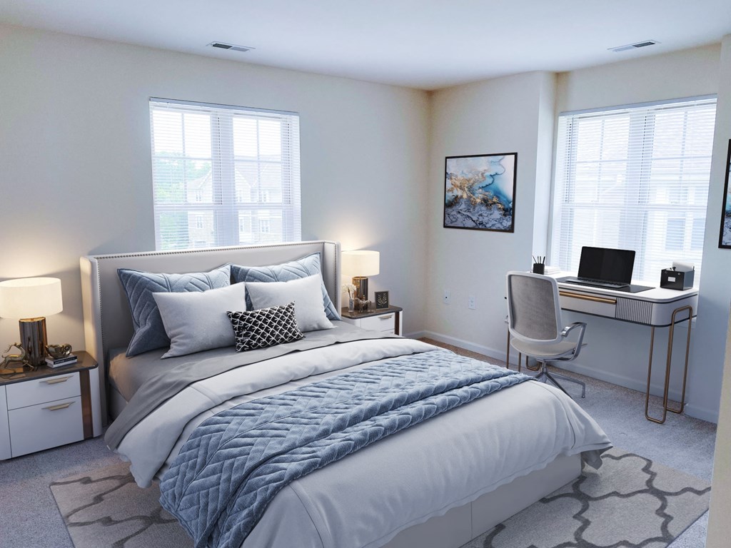 a bedroom with a bed and a desk with a laptop