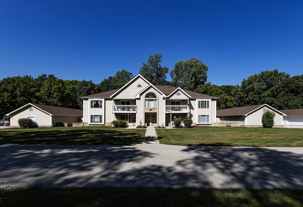 a large white house with a driveway and lawn