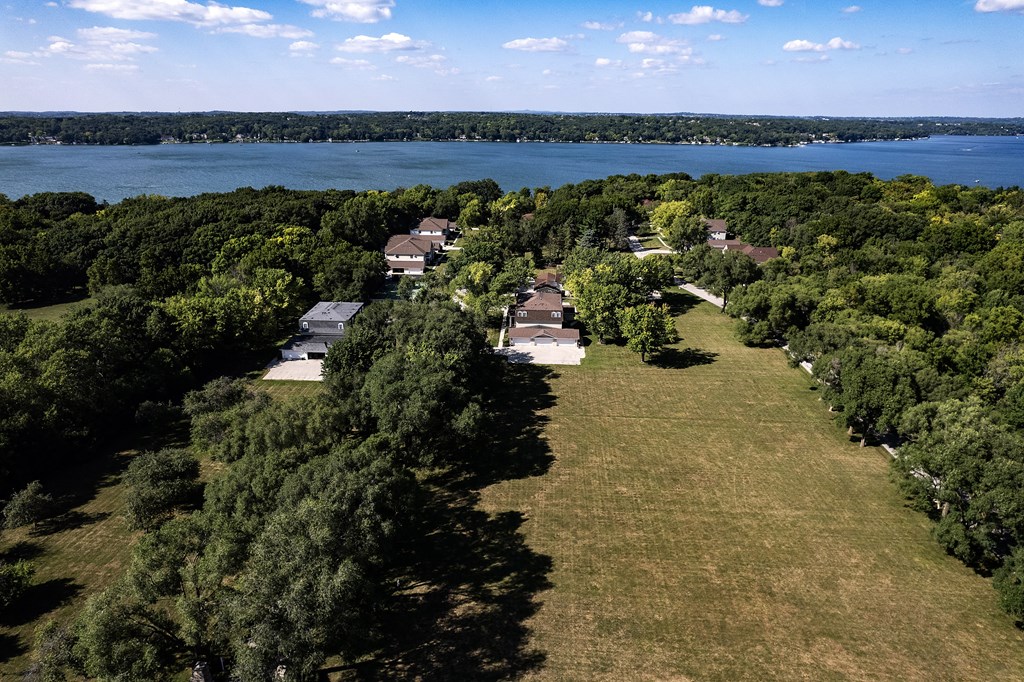 an aerial view of a neighborhood with a body of water in the background